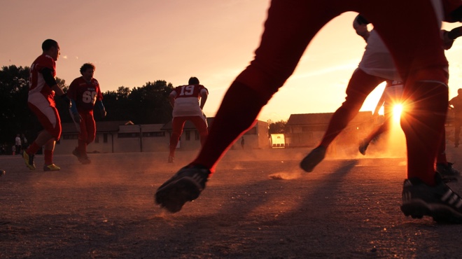 People playing football at sundown